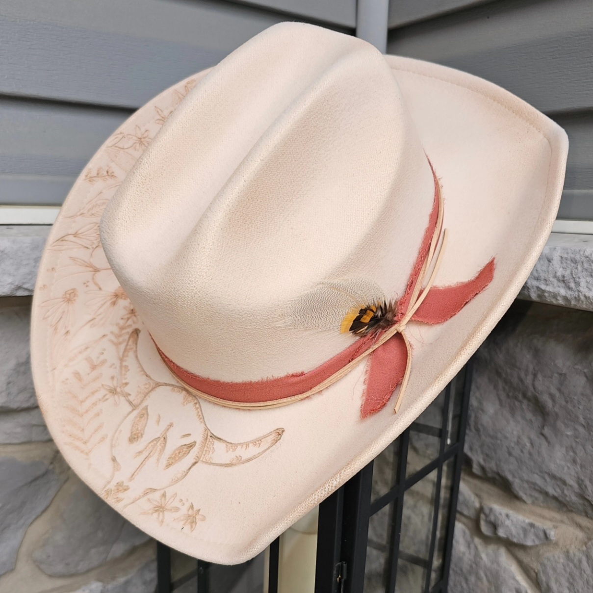 Cattleman hat with floral and skull design finished with coral chiffon band $100