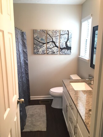 master bathroom with linen closet across from a granite double vanity
