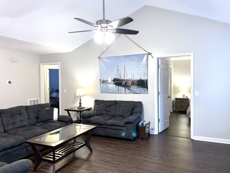 master suite on the right side of living room love sofa and hallway to other 2 bedrooms and bath on the left side
