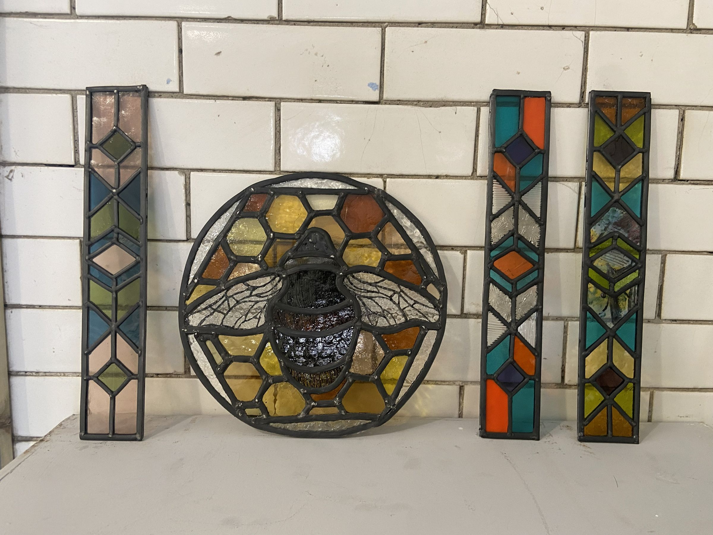 Three small Aztec-inspired pieces and one bee honeycomb piece