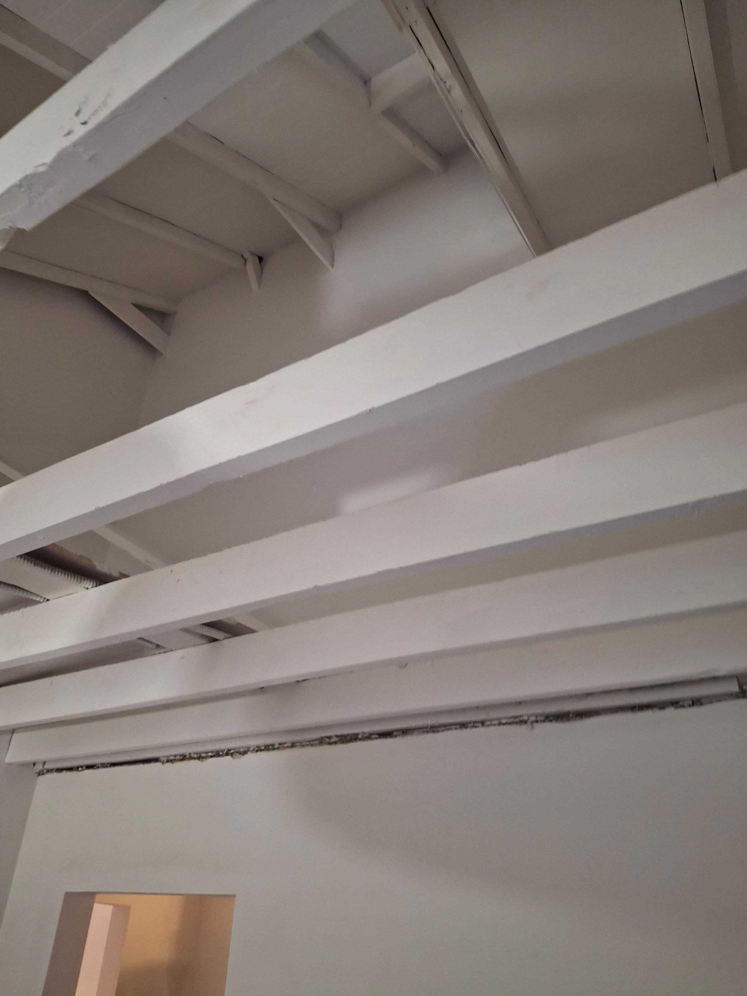 Finished ceiling – white painted beams and smooth surface