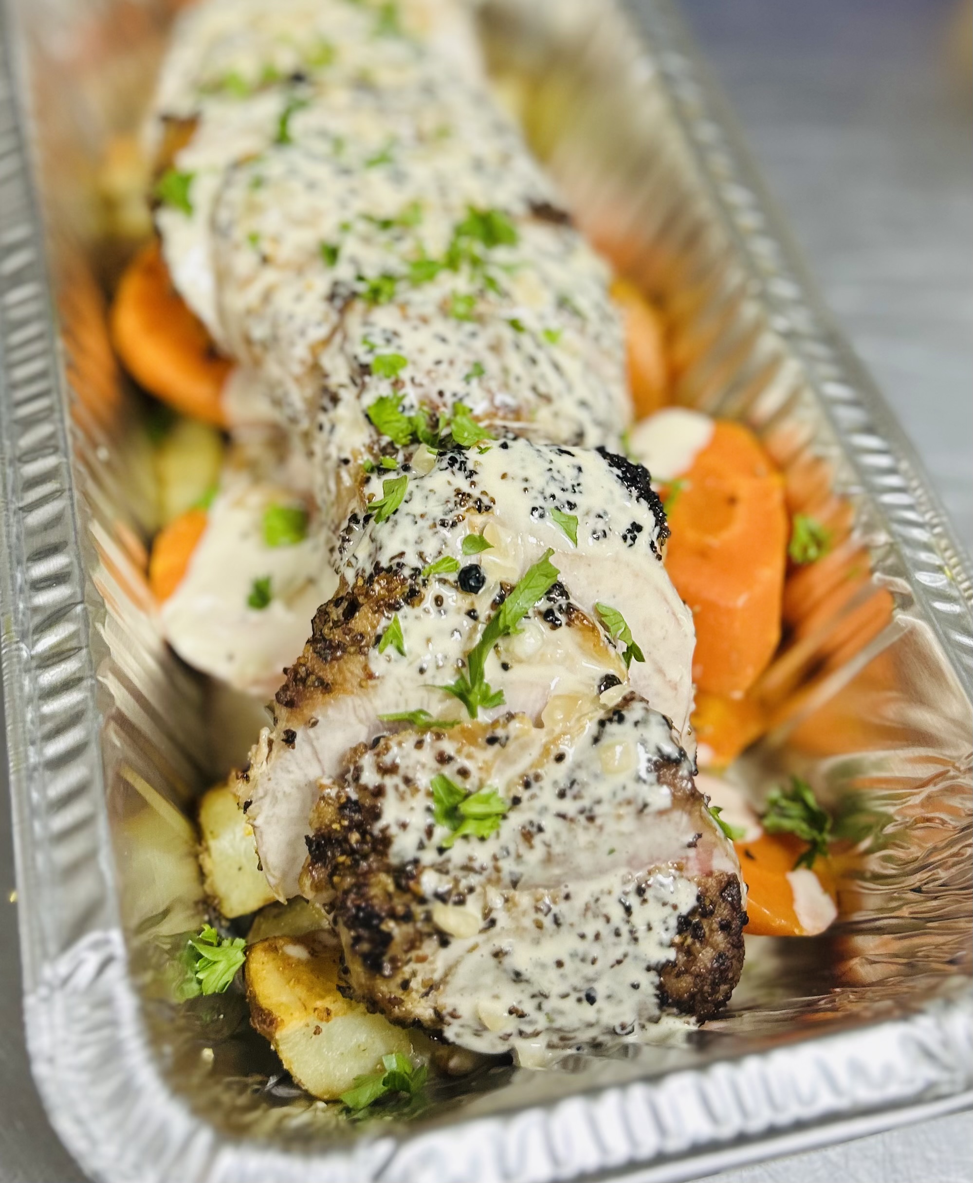 Pork Tenderloin Au Poirve: Black Pepper Seared Pork Tenderloin with Cognac Cream Sauce, Roasted Russet Potatoes and Roasted Carrots.