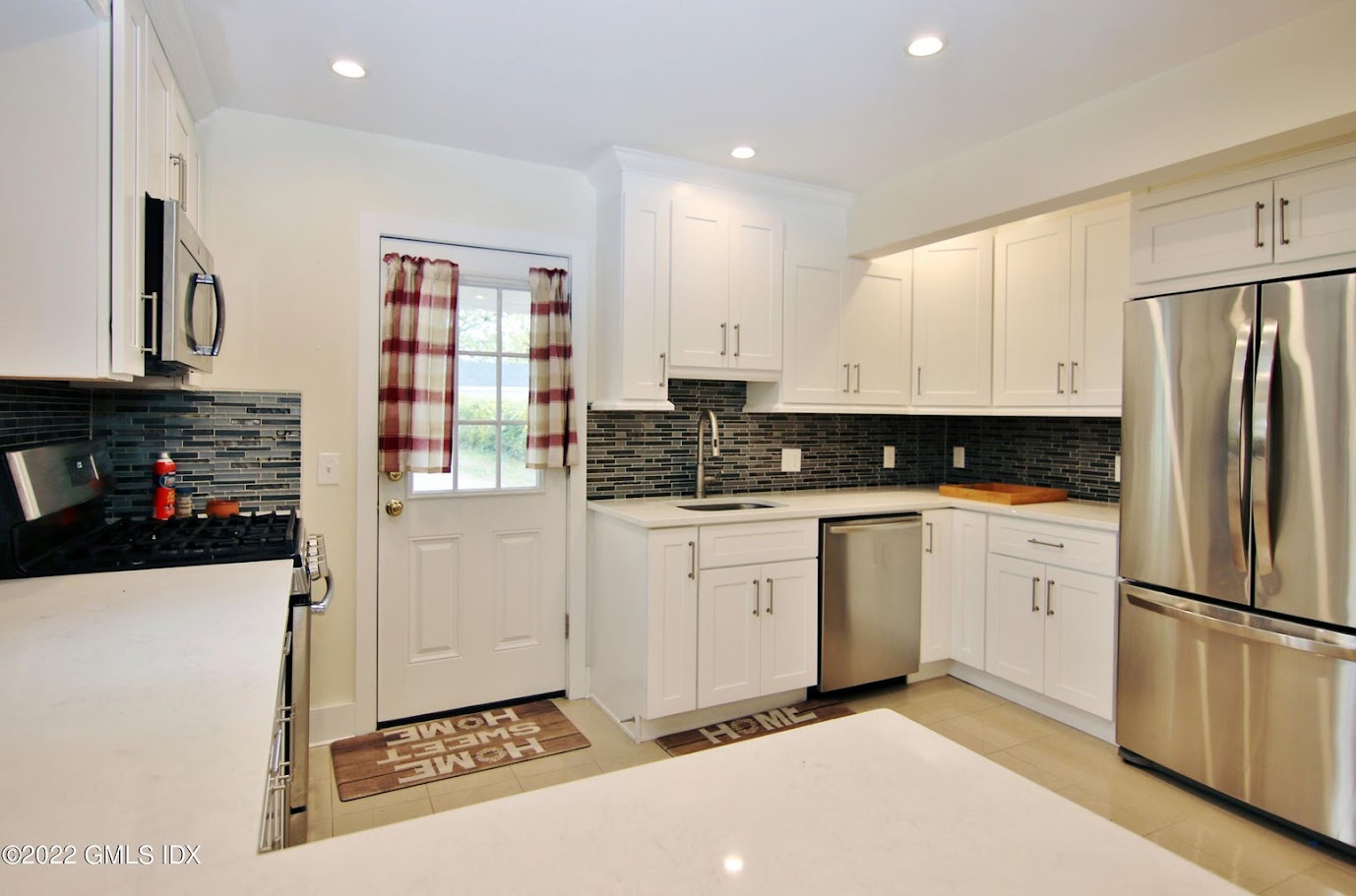 Shaker Kitchen, Mixed Glass Backsplash, Stainless Appliances and Crema Polished Floor