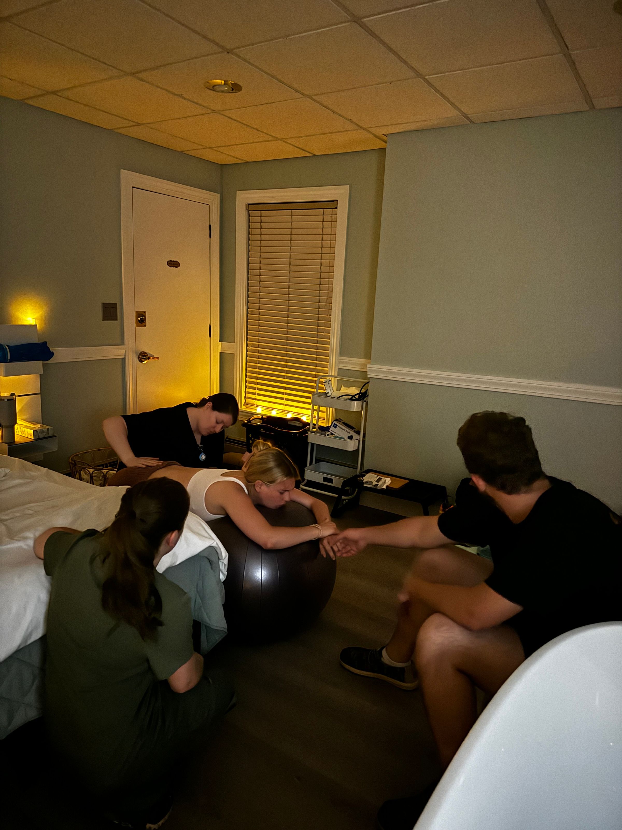 Birth team supporting a laboring client in the center