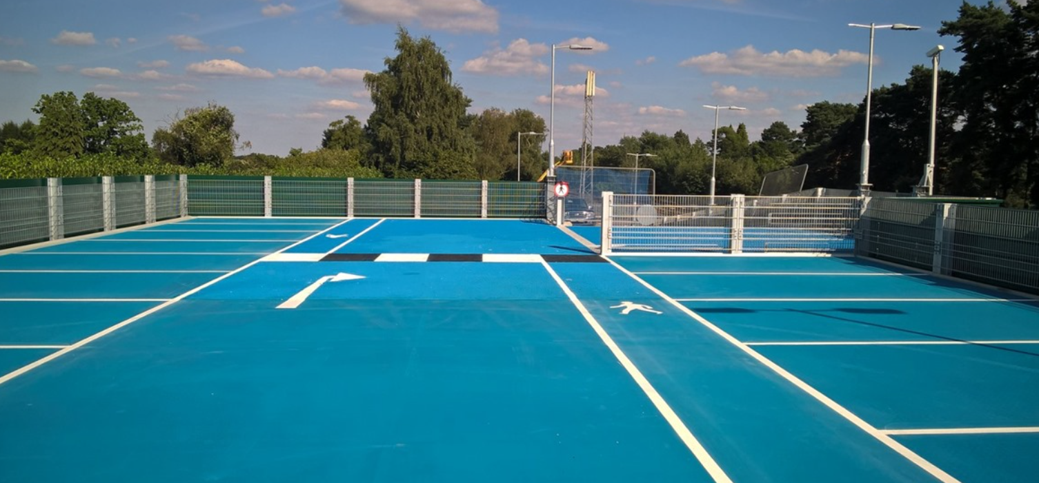 Textured blue paint to provide grip on the top level of a multi story carpark.