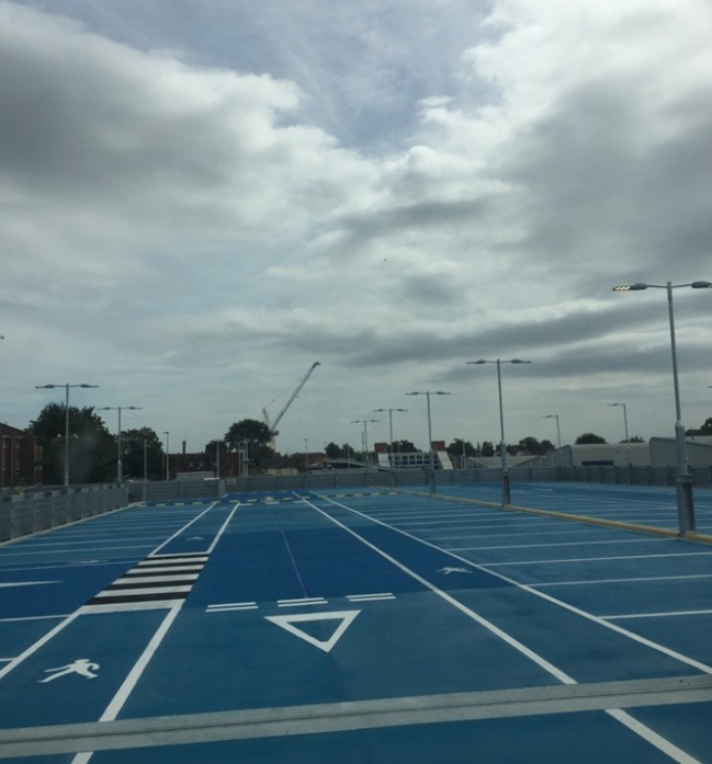 Textured blue paint to provide grip on the top level of a multi story carpark.