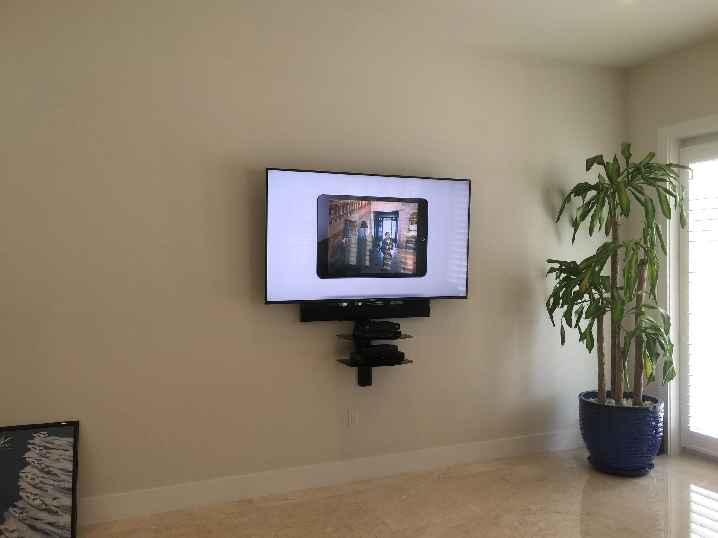 60-inch TV mounted with soundbar and double floating shelf installation in Homestead, FL.