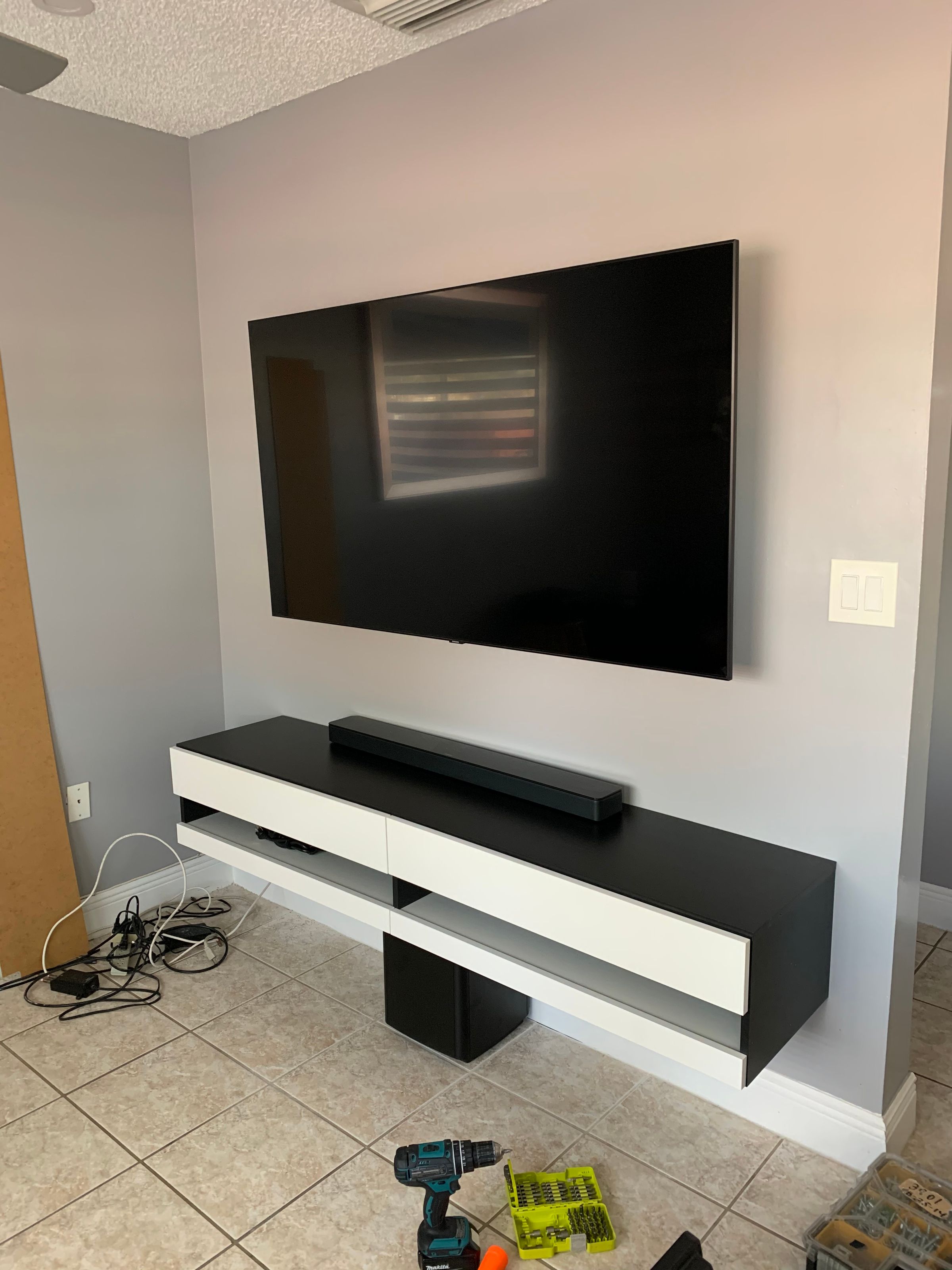 Mounted TV with wall shelf unit installed in a Homestead home.