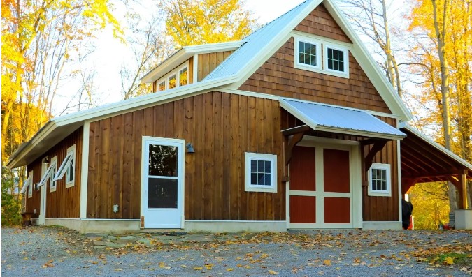 Front entrance to lodge with picnic table and grill on the side 