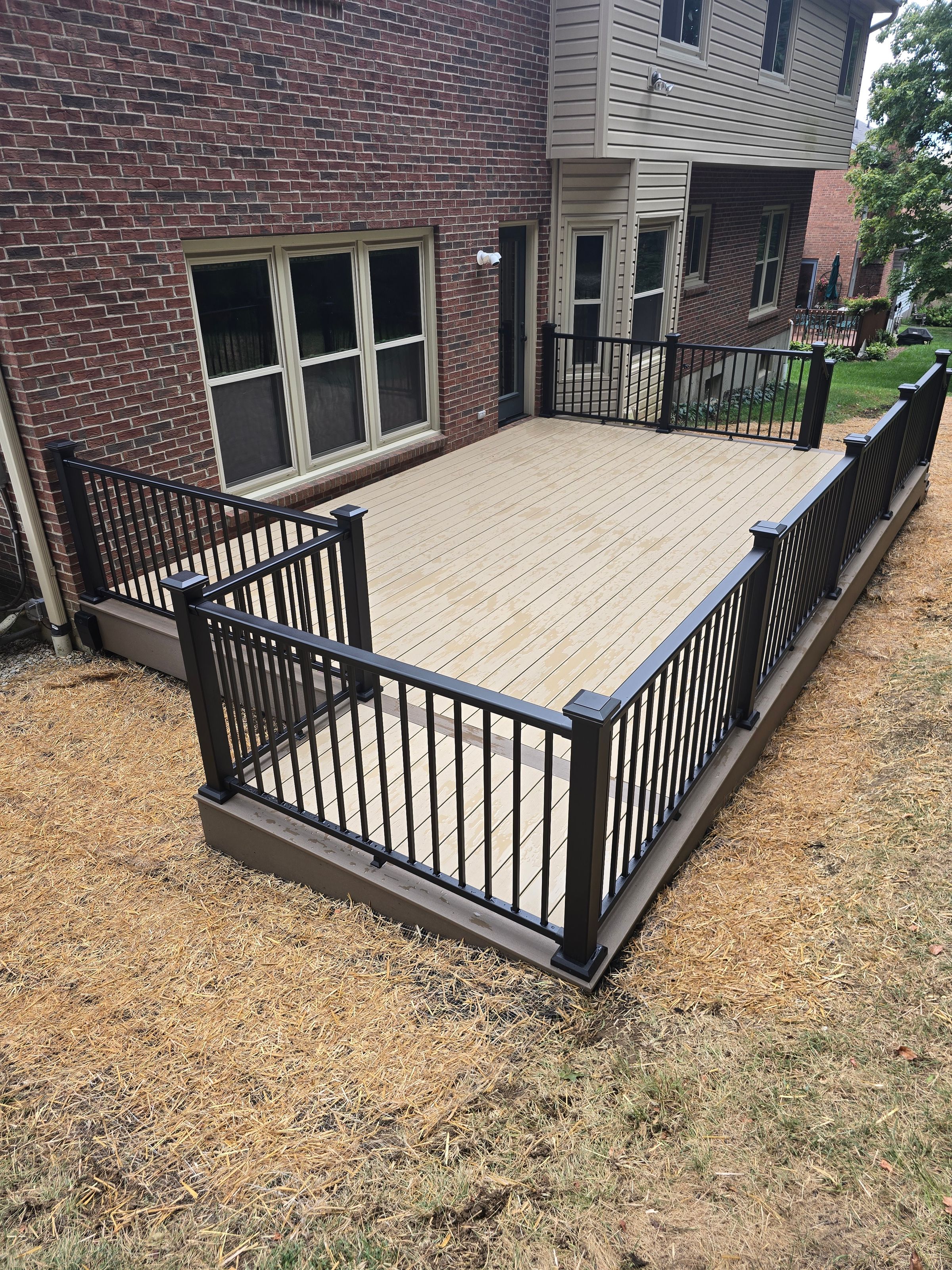 Composite deck w/ black aluminum rails w/ post and step lighting