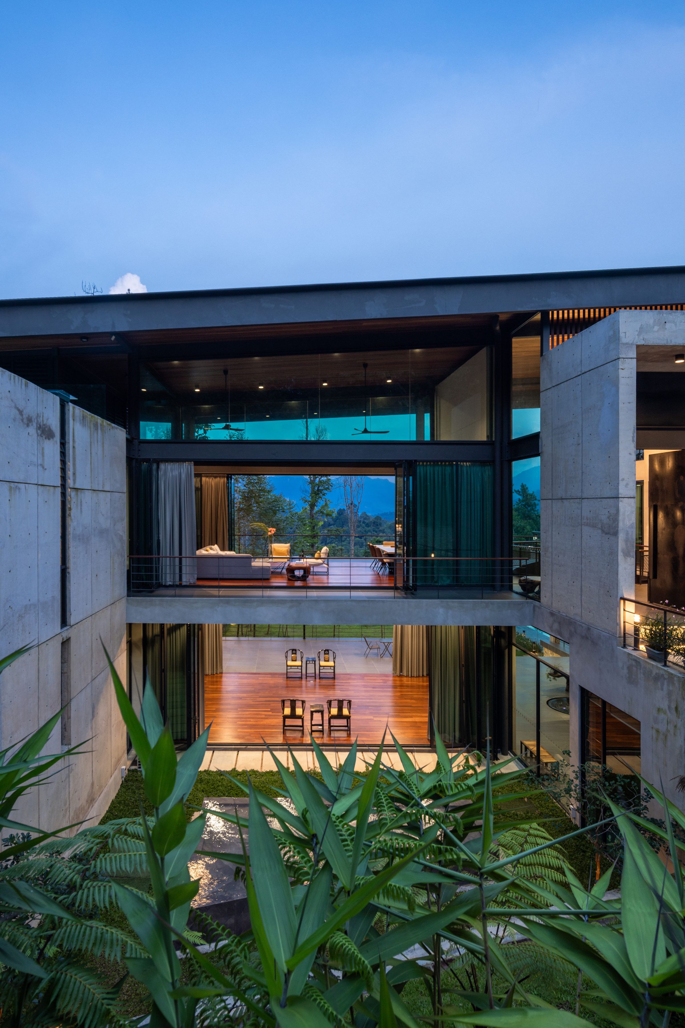 SereneNest private wellness villa at night with warm interior lights against the Janda Baik forest