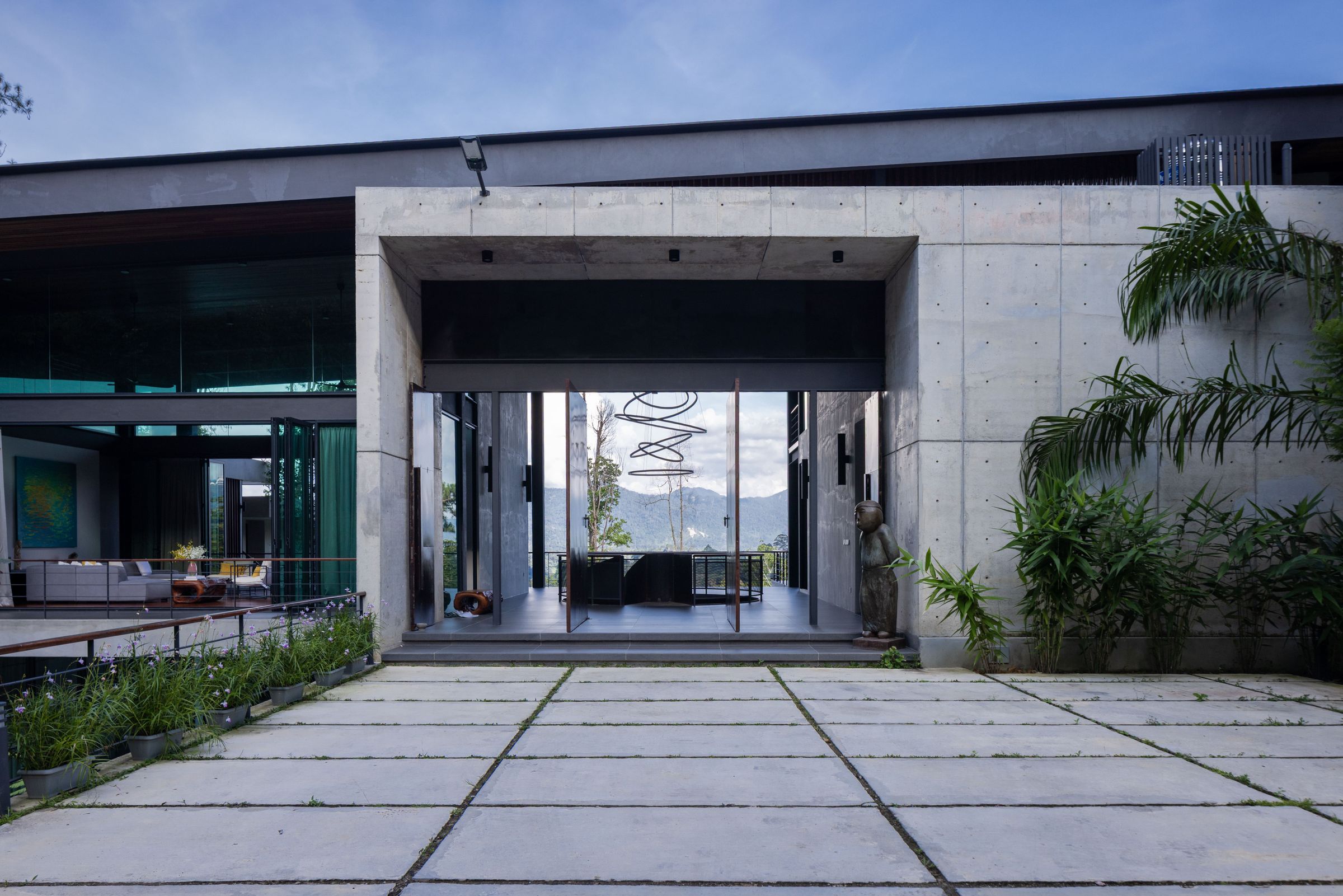 Covered entrance walkway at SereneNest with concrete paving and rainforest greenery