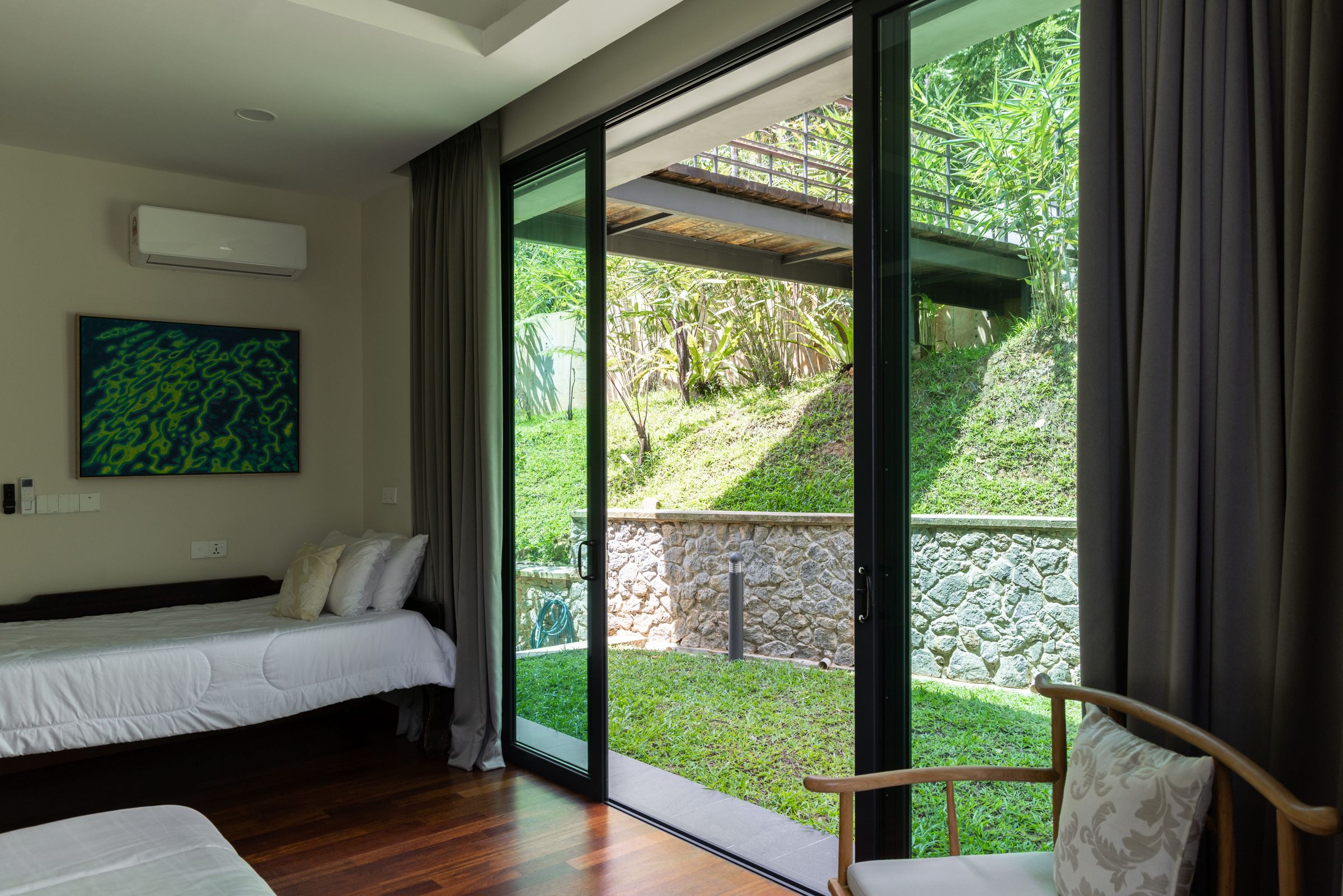 Guest bedroom at SereneNest with a sliding glass door opening onto the garden