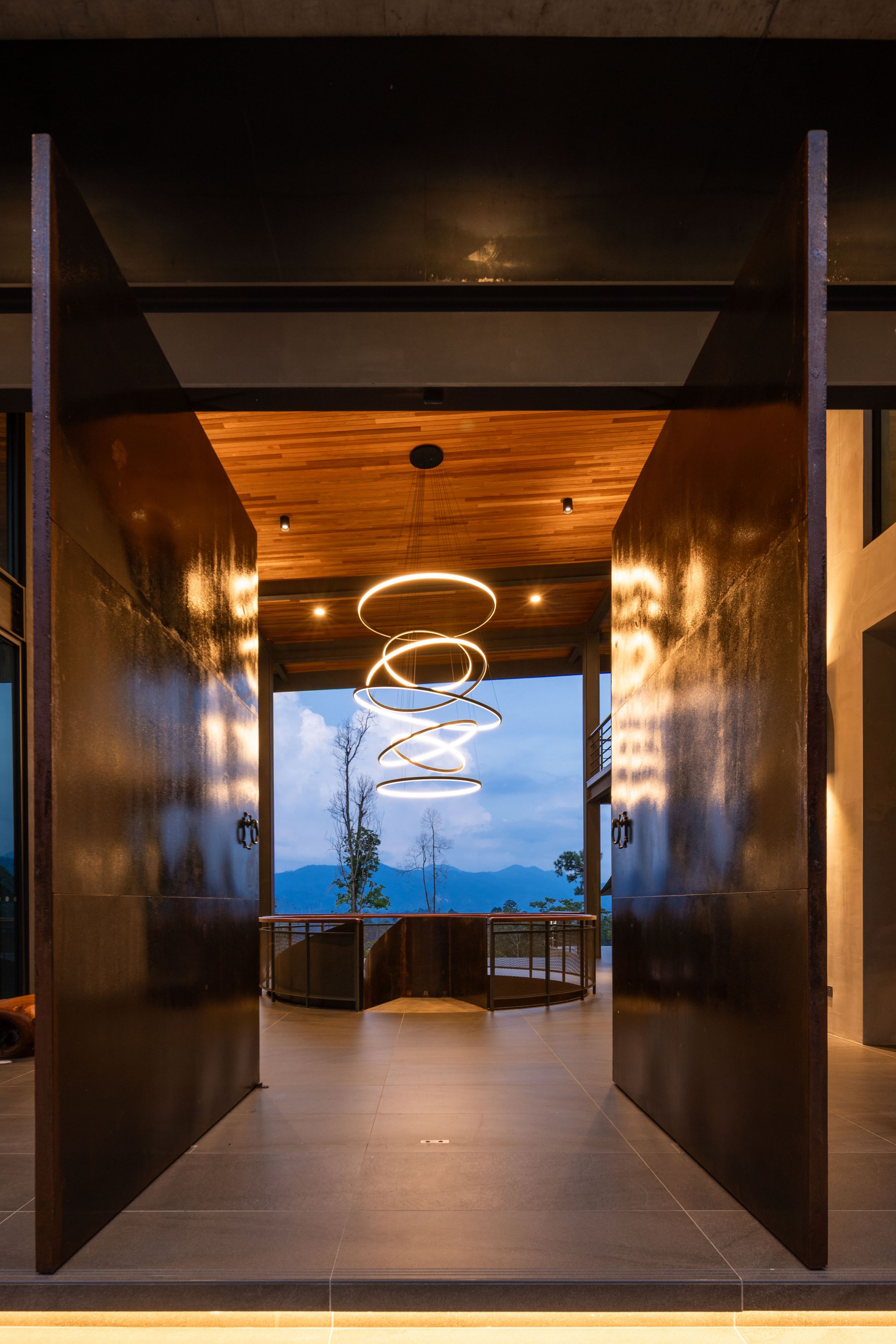 Dark interior corridor at SereneNest with a sculptural spiral chandelier at its end