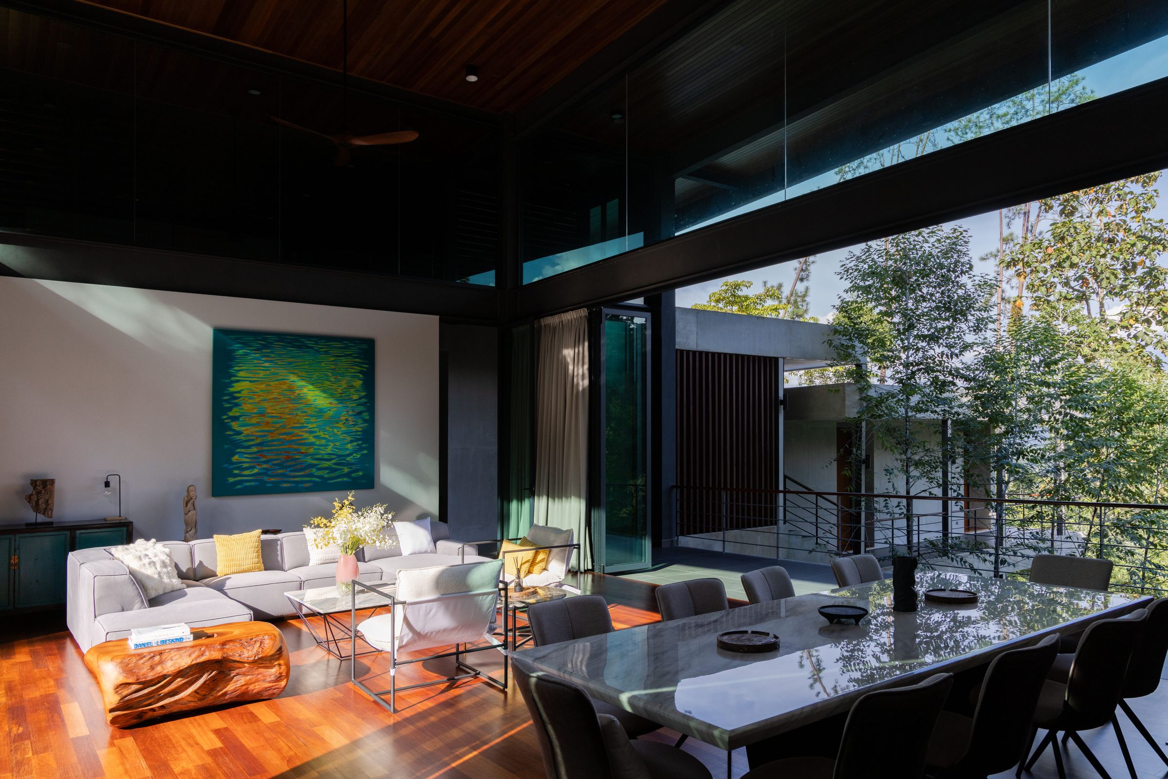 Living and dining area at SereneNest with full-height glass framing the rainforest