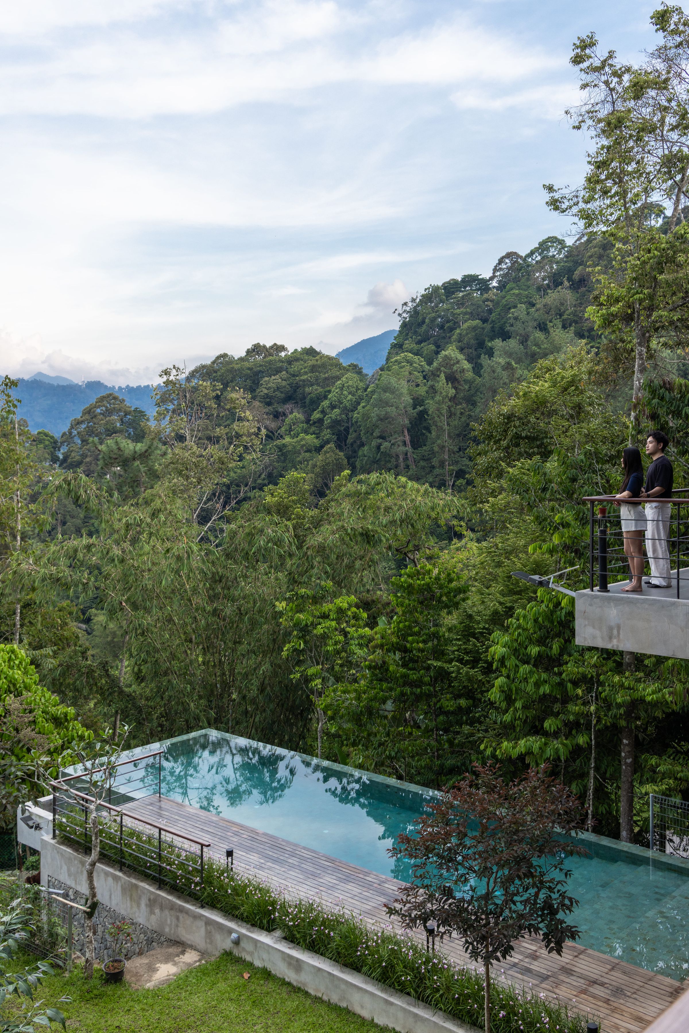 Wide timber balcony at SereneNest opening to the infinity pool and forest view