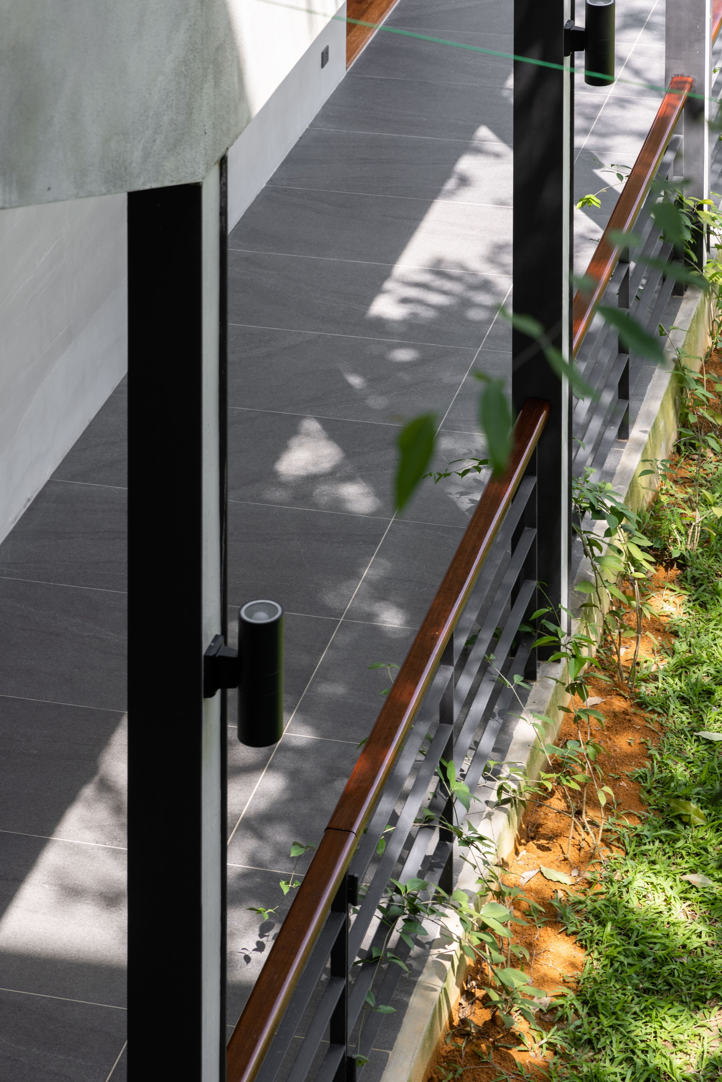 Exterior side walkway at SereneNest with concrete walls and rainforest at the edge