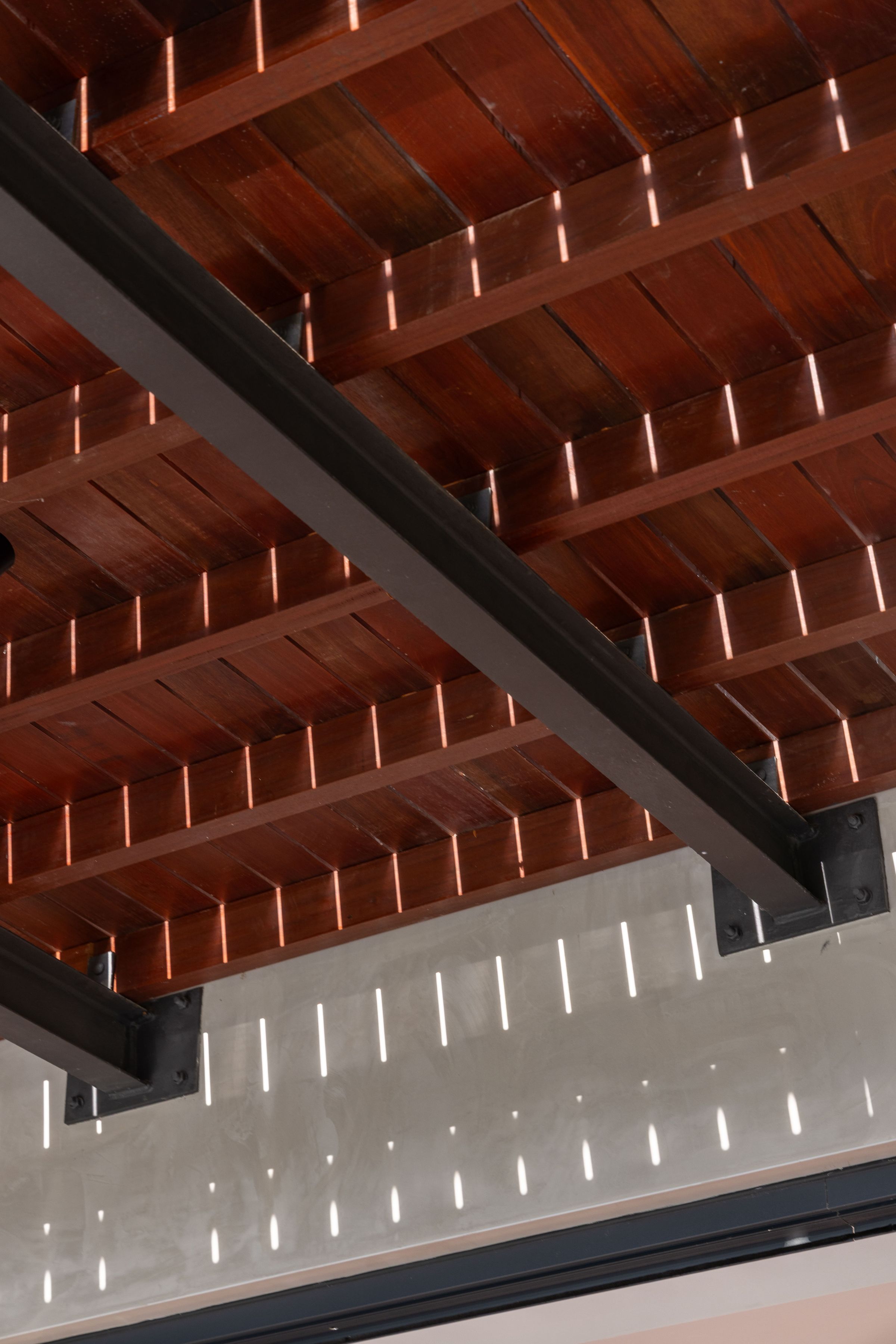 Looking up at the timber slatted pavilion roof at SereneNest with patterned daylight