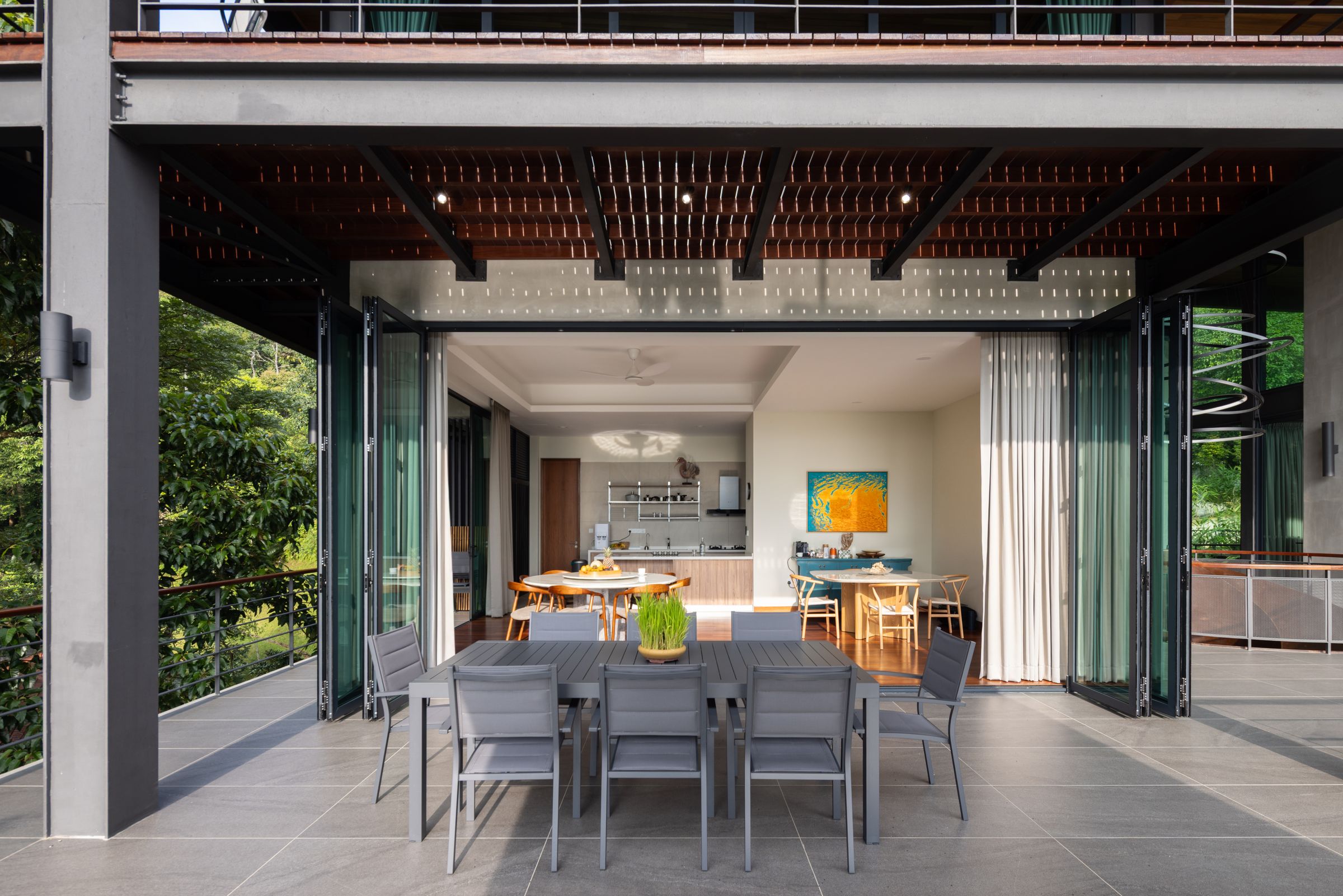 Long shared dining table at SereneNest set for a private group retreat with open walls