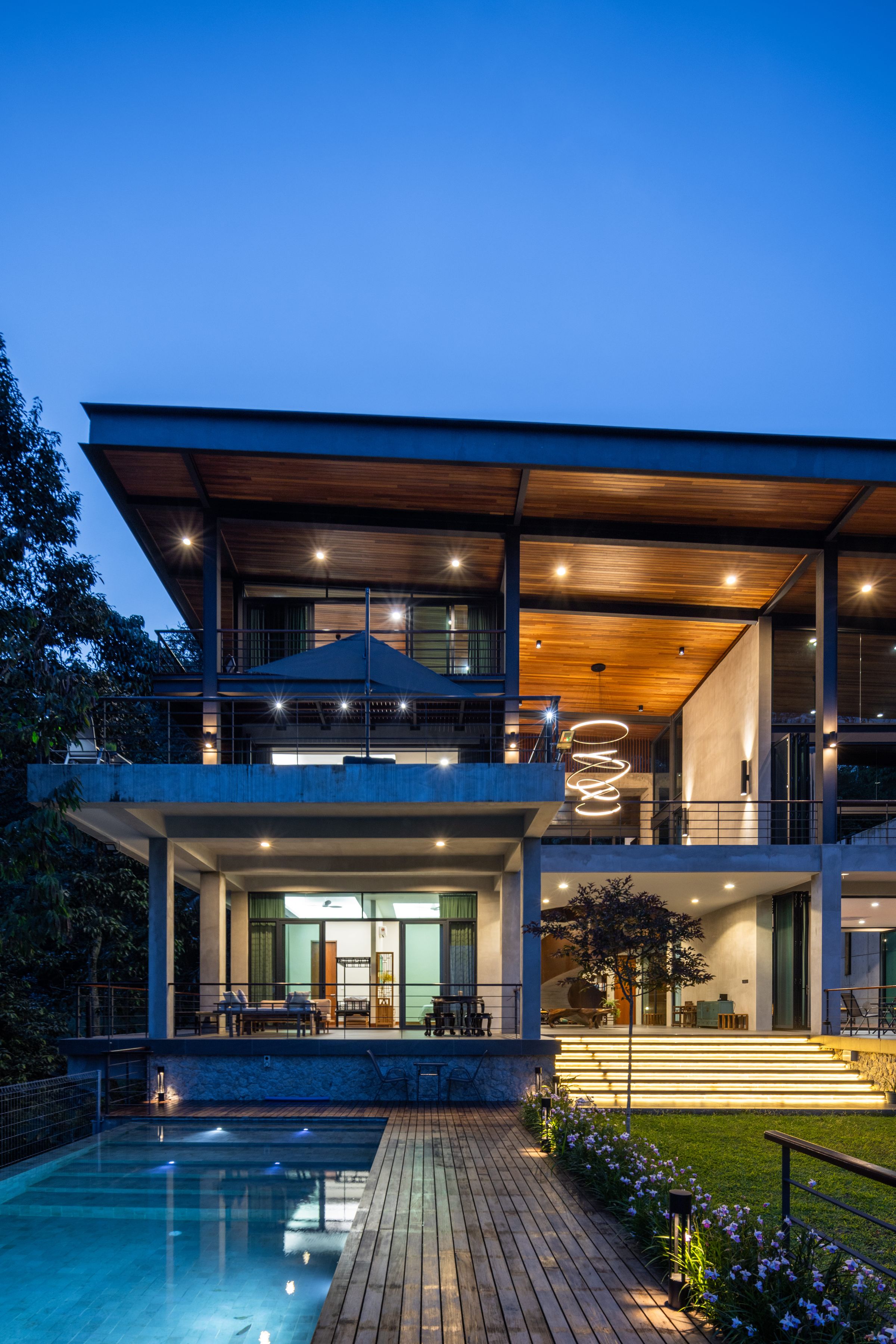 SereneNest villa at dusk with the infinity pool and timber deck in the foreground