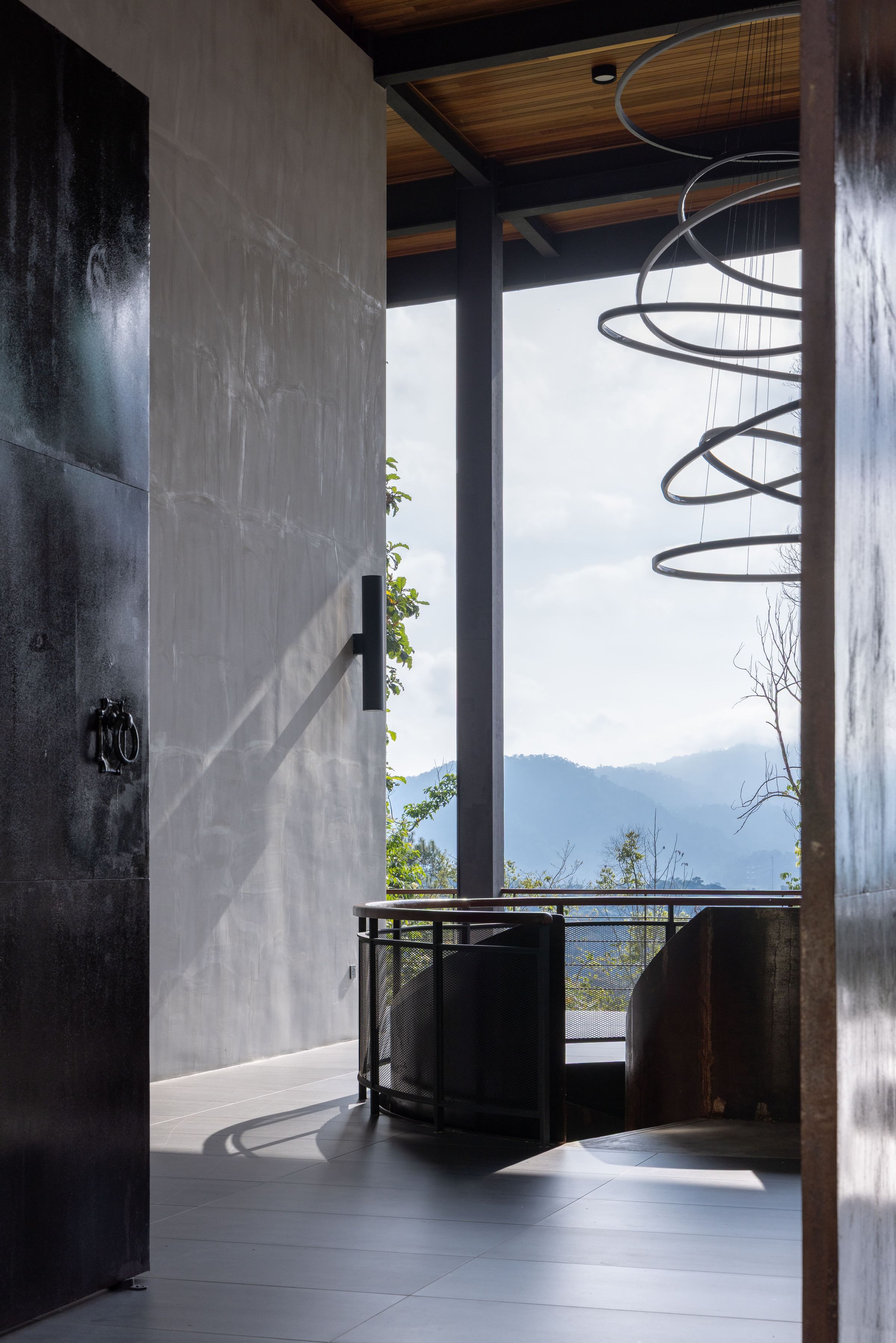Inside the SereneNest entry hall with the spiral chandelier glowing softly in the dark