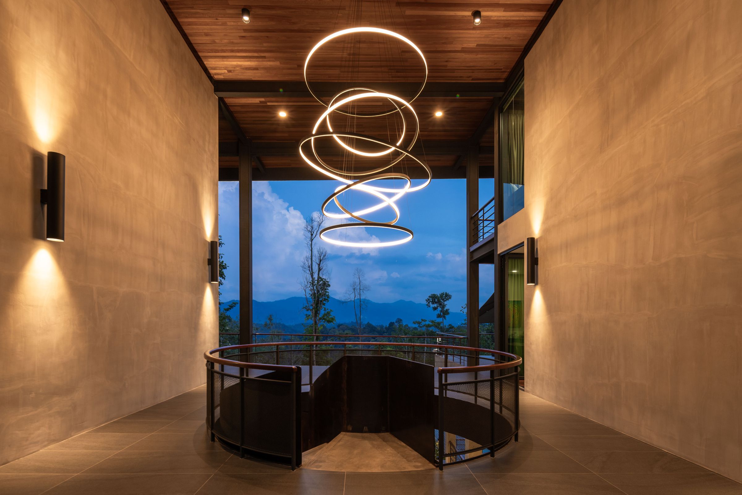 Entry foyer at SereneNest with timber ceiling, spiral chandelier and stone walls