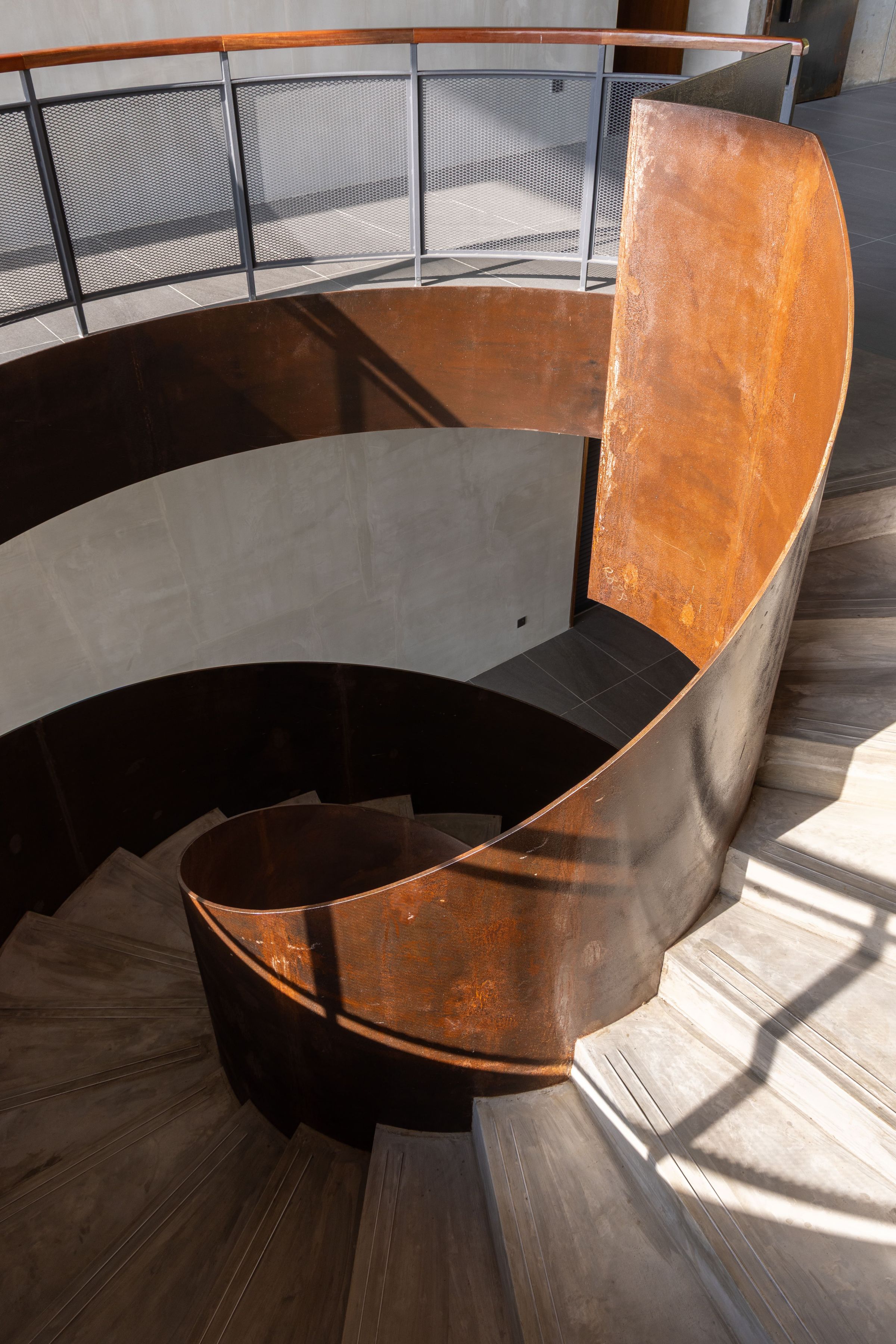 Looking down at the timber spiral staircase at SereneNest from the upper landing