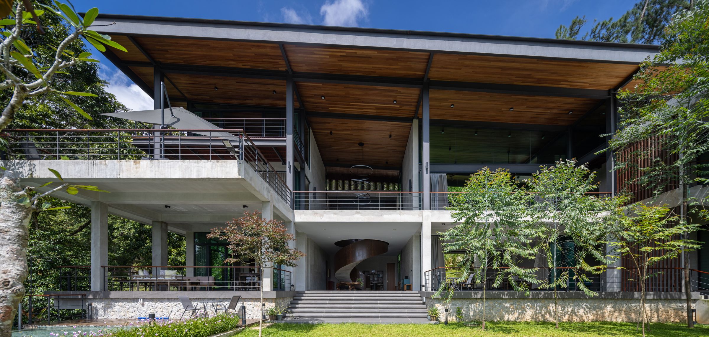 Side elevation of the SereneNest villa with a cantilevered roof and forested slope