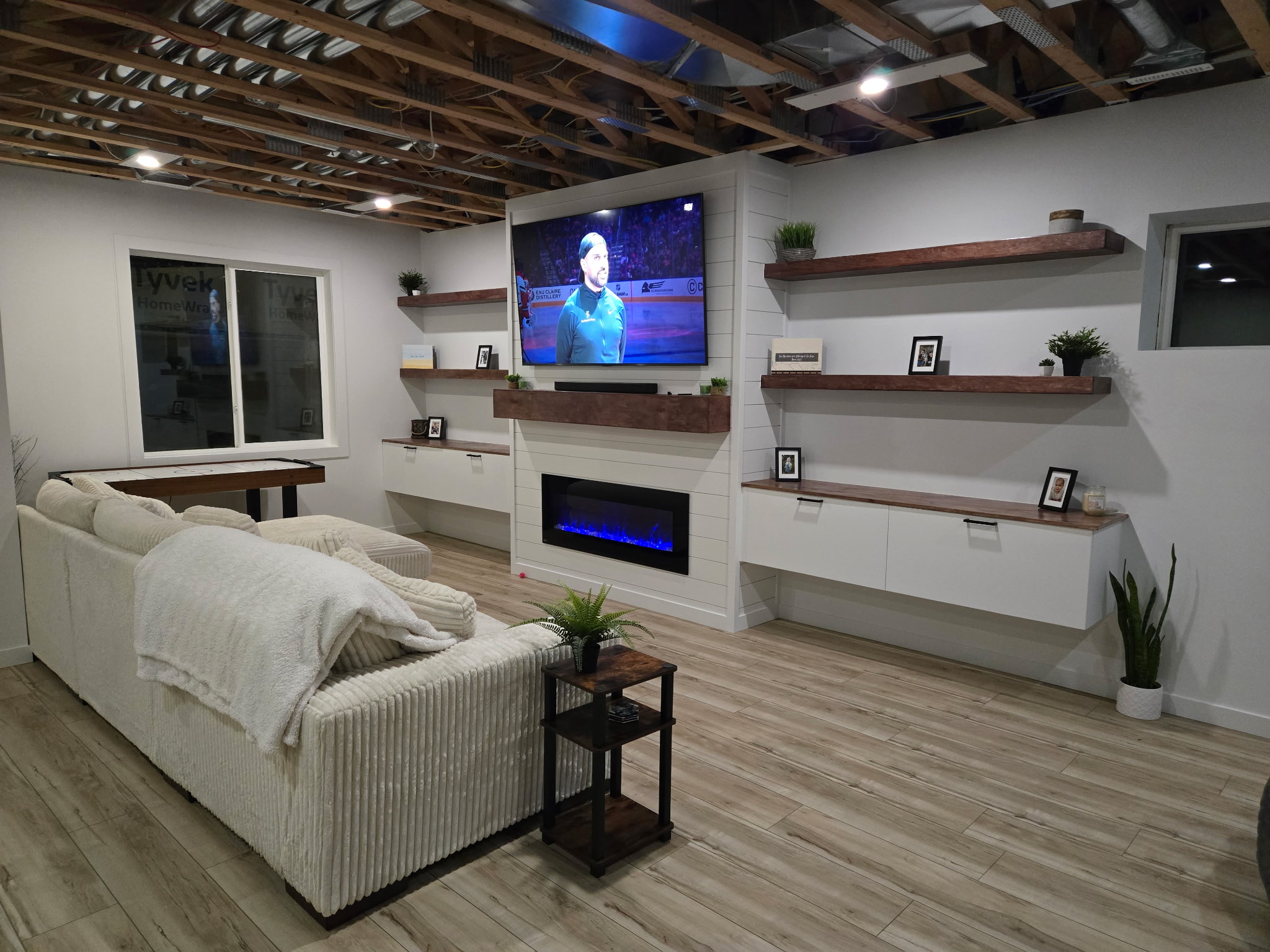 Drywall mud and tape job, electrical, vinyl plank flooring, custom floating shelves and cabinets, and fireplace