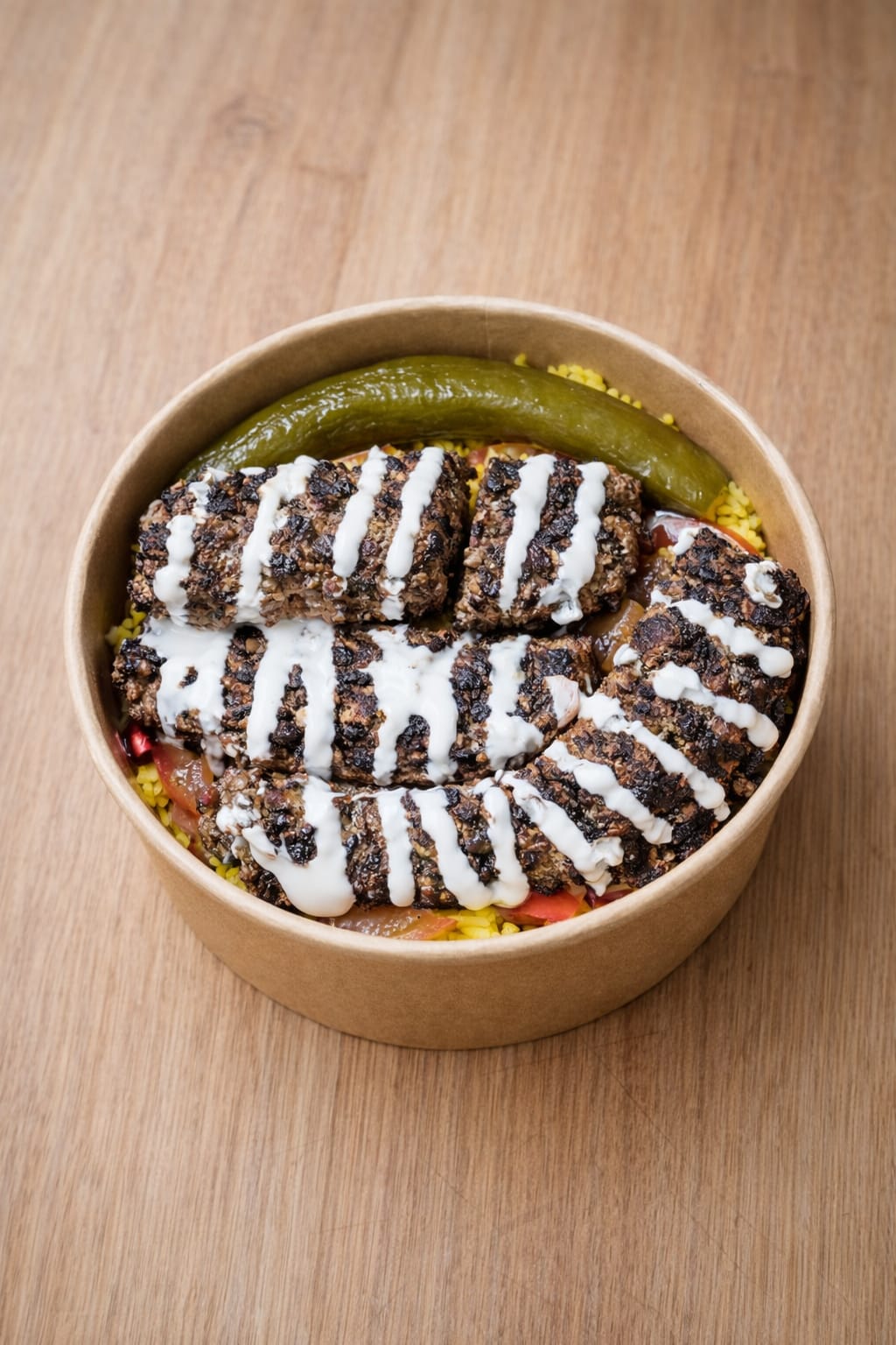 served over yellow rice with dill pickles, tomatoes, sumac onions, fresh pomegranate seeds, and tahini sauce.