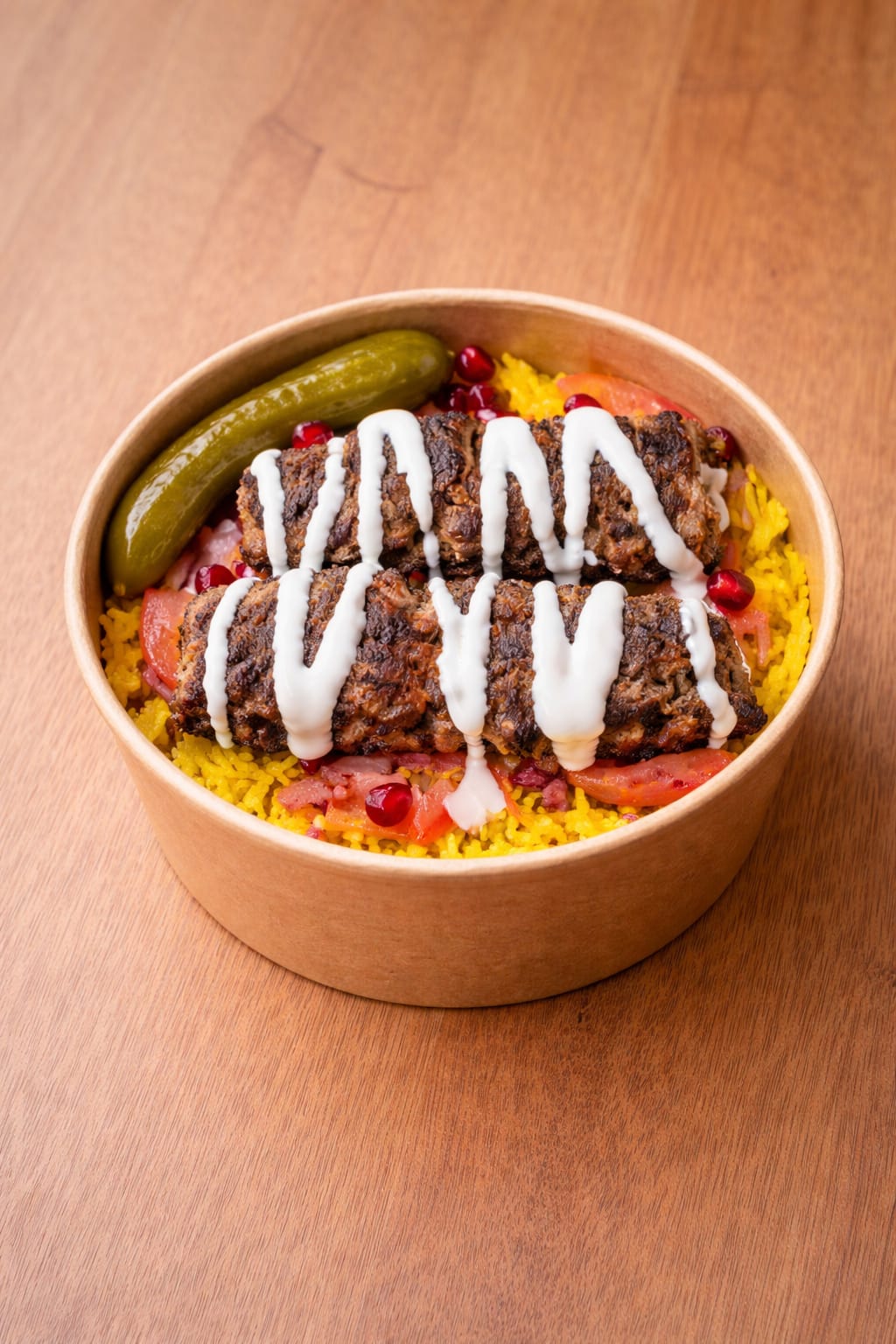 served over yellow rice with dill pickles, tomatoes, sumac onions, fresh pomegranate seeds, and tahini sauce.