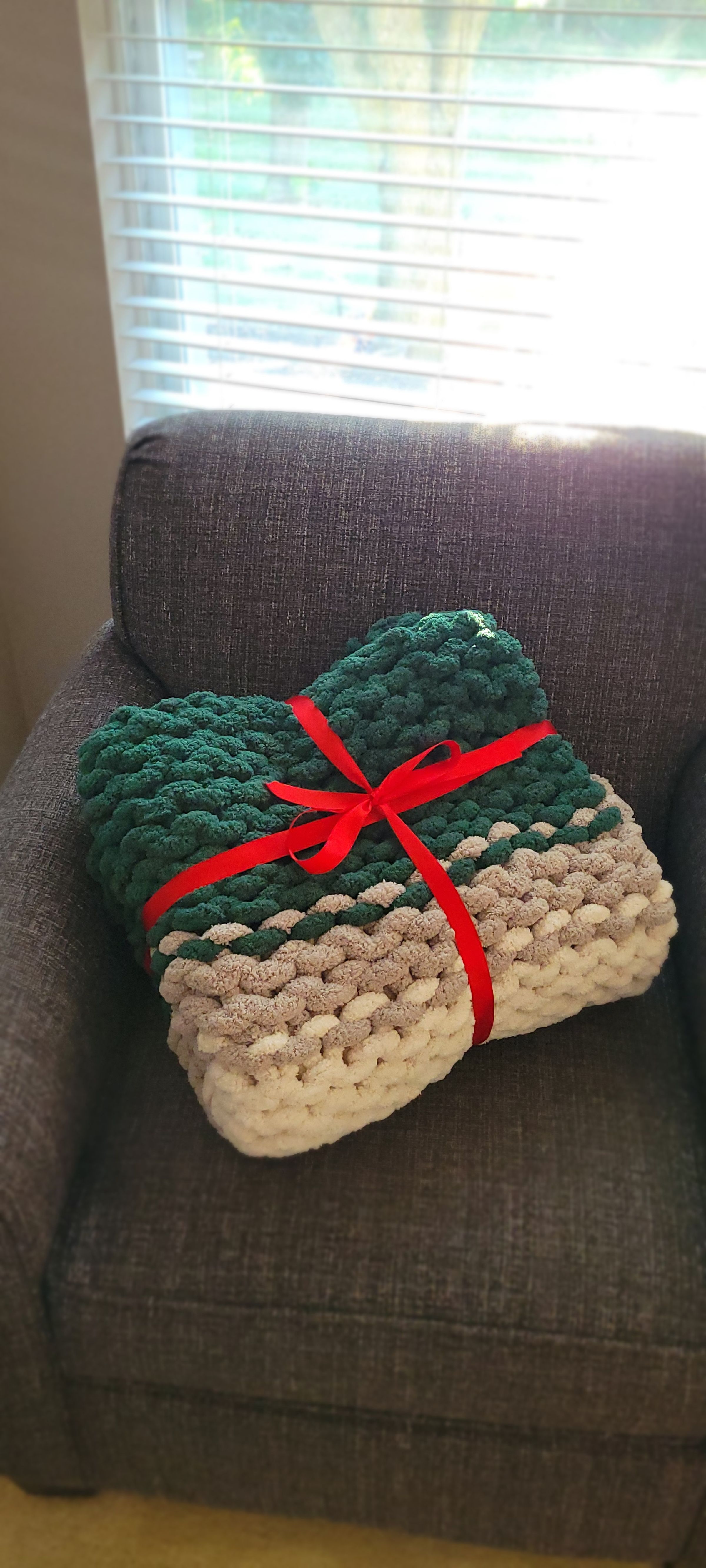 Three-tone throw (forest green, gray, and ivory): Hand-knit with tightly packed, small loops. The dense stitch gives it a structured feel while keeping the blanket soft and cozy, perfect for gifting or curling up in.