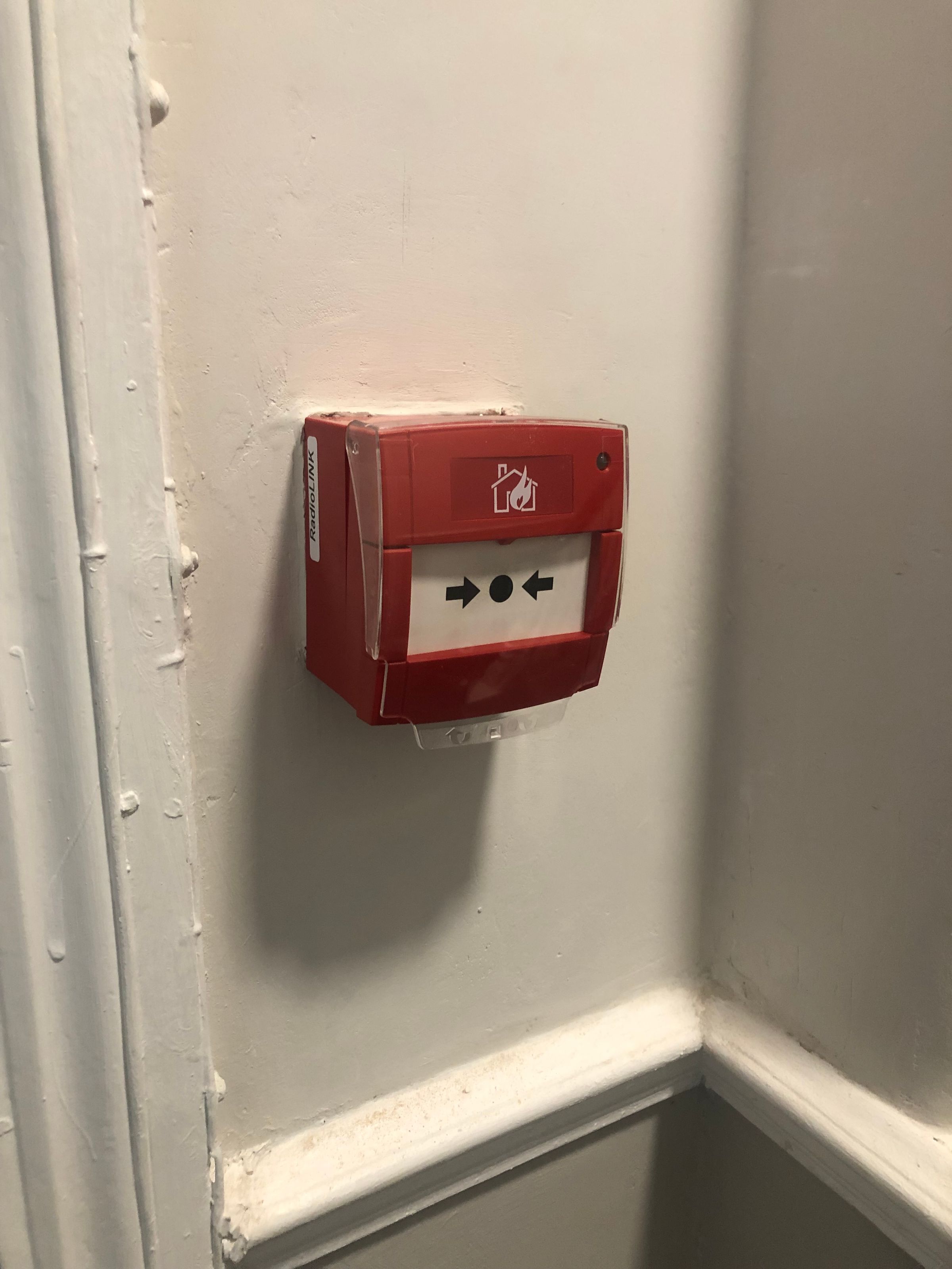 Wireless connected call point installed as part of a communal fire alarm system in Hackney